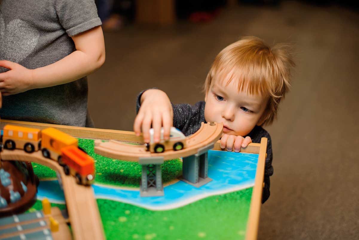Niño jugando con carrito de madera