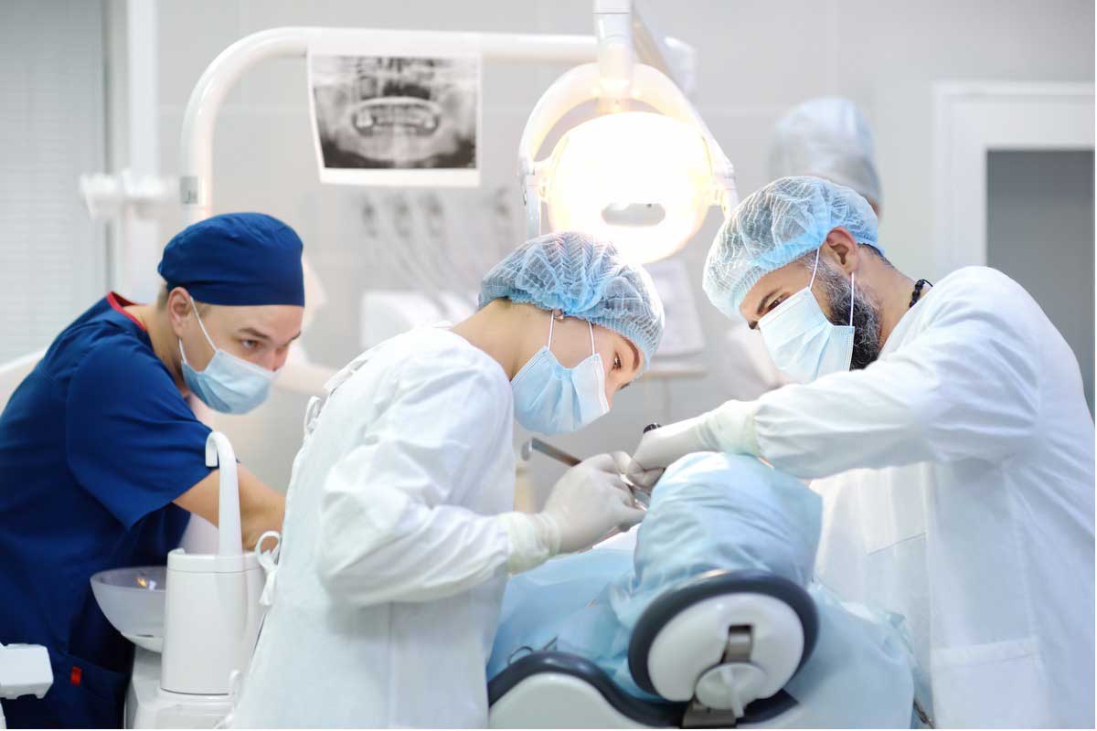 Grupo de odontólogos realizando un procedimiento a un paciente
